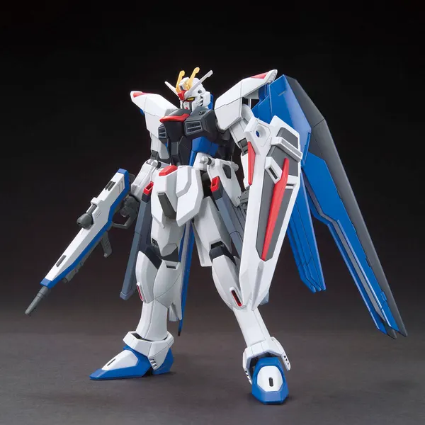 HGCE 1/144 フリーダムガンダムの公式の商品写真。白と青の機体が青い翼を広げ、ビームライフルとシールドを持っている
